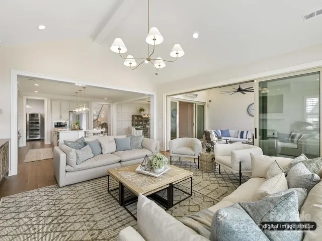 a living room with furniture a chandelier and a rug