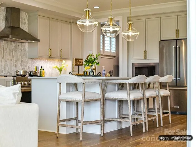 a kitchen with stainless steel appliances kitchen island granite countertop a table and chairs in it