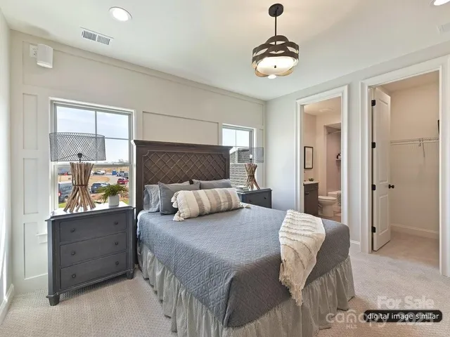 a spacious bedroom with a bed and a chandelier