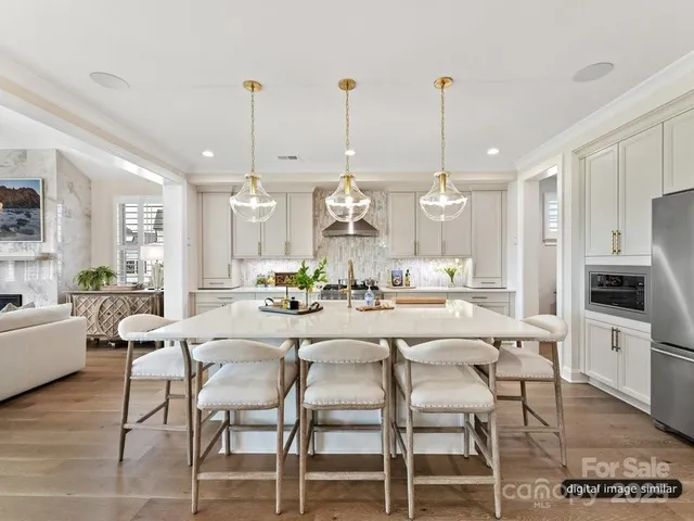 a dining room with furniture a chandelier and kitchen view