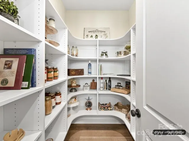 a view of a kitchen with stainless steel appliances granite countertop a lot of cabinets and a wooden floor
