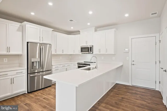 a kitchen with appliances a sink and cabinets