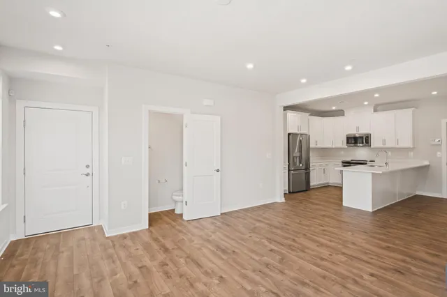 a living room with furniture and a dining table with wooden floor