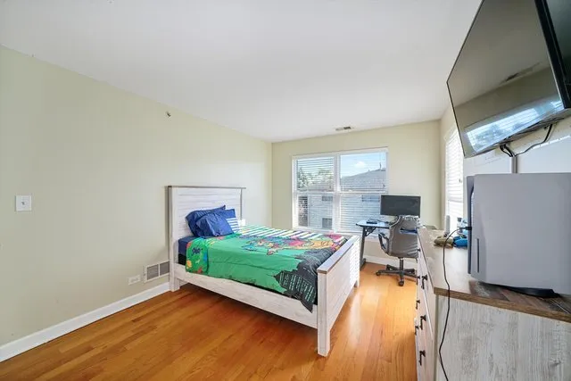a bedroom with a bed and wooden floor