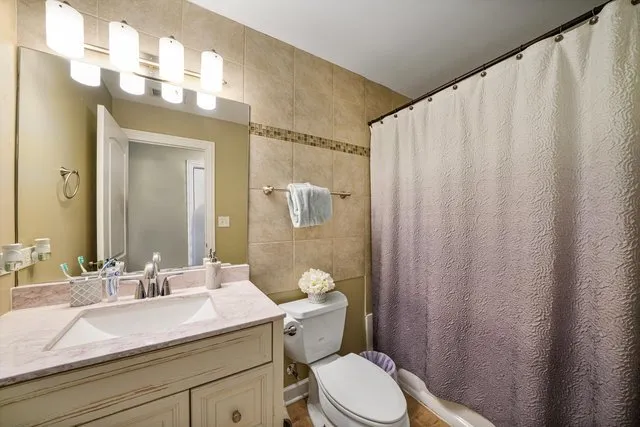 a bathroom with a sink a toilet and shower curtain