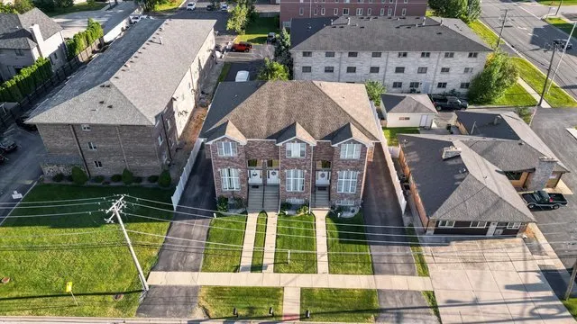 an aerial view of multiple houses with a yard