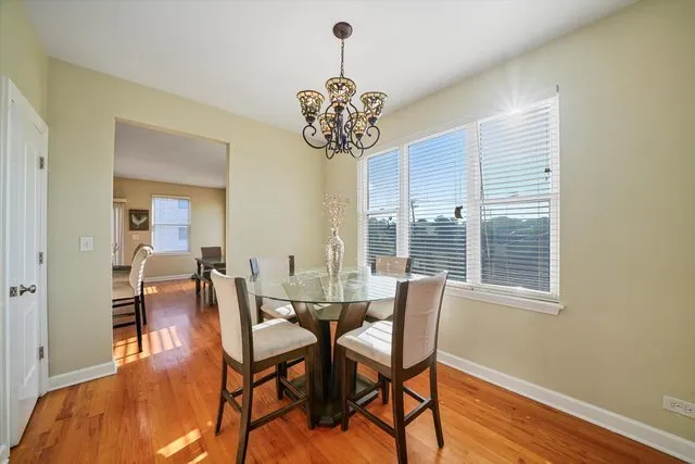 a view of a dining room with furniture wooden floor and chandelier