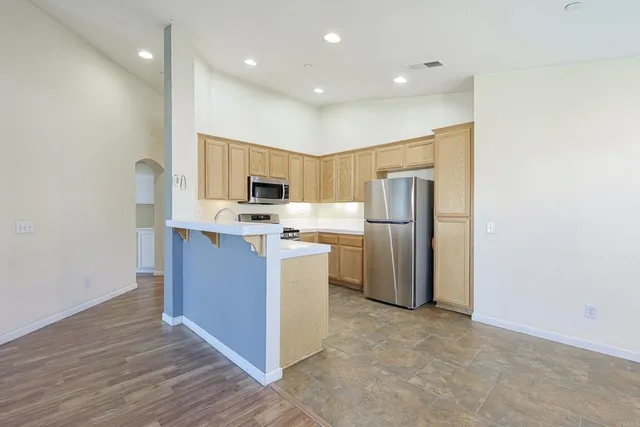 a kitchen with refrigerator cabinets and wooden floor