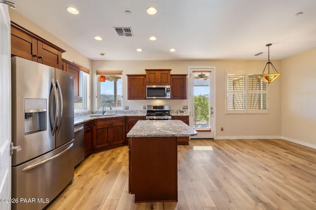 a kitchen with stainless steel appliances granite countertop a refrigerator a stove top oven a sink and dishwasher