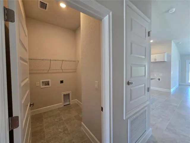 an empty room with a window and a kitchen