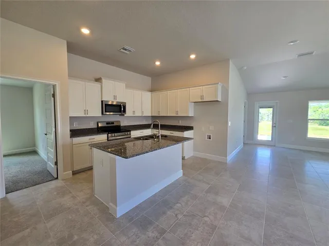 a kitchen with stainless steel appliances granite countertop a sink stove and cabinets