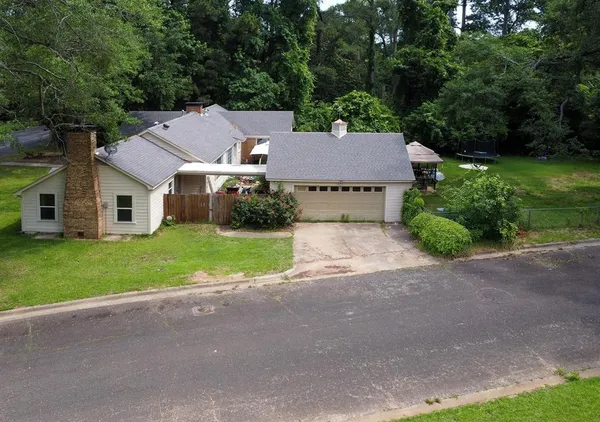 a aerial view of a house with yard and green space