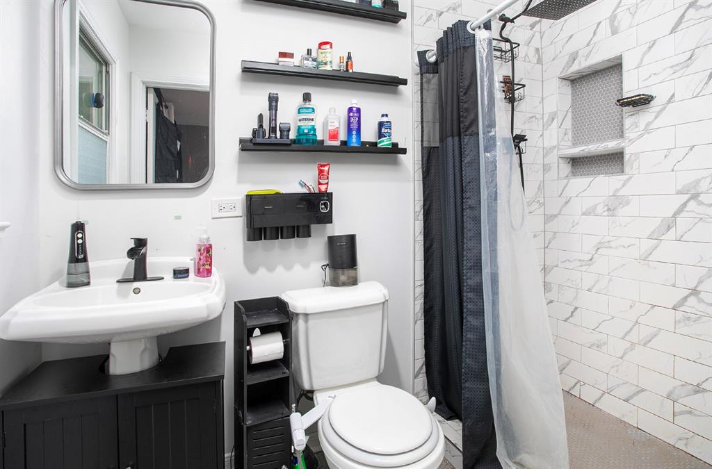 2414 South Martin Street Kilgore, TX 75662 - Photo 18 of 38 a bathroom with a sink toilet and a mirror