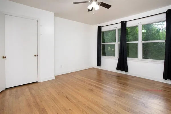 a view of a room with wooden floor and a ceiling fan