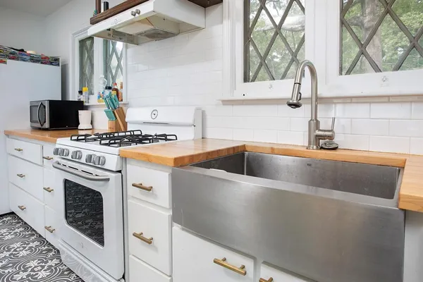 a kitchen with kitchen island granite countertop a sink and cabinets