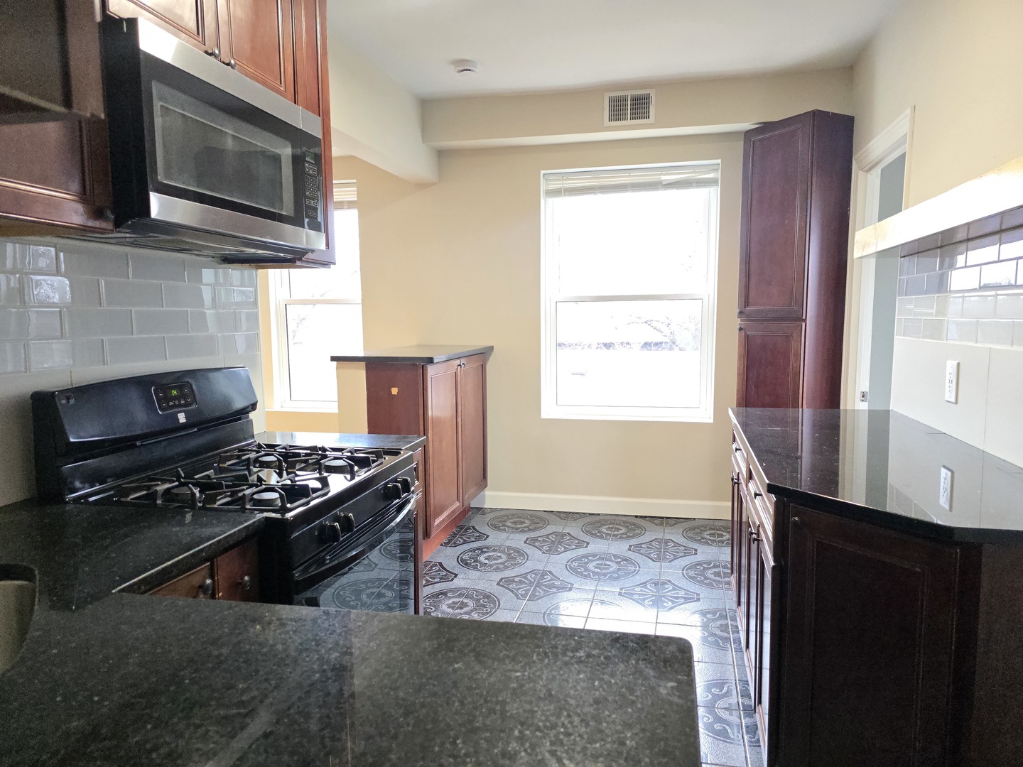 3507 West Belden Avenue, Unit 3 Chicago, IL 60647 - Photo 5 of 15 a kitchen with stainless steel appliances granite countertop a stove a microwave and a sink