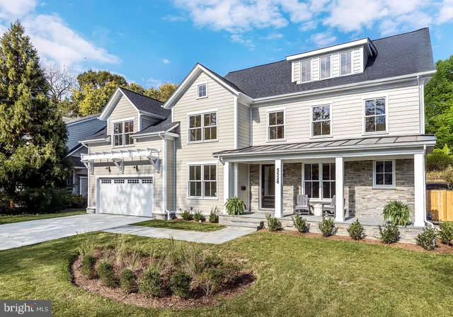 a view of a white house with large windows and a yard with palm trees