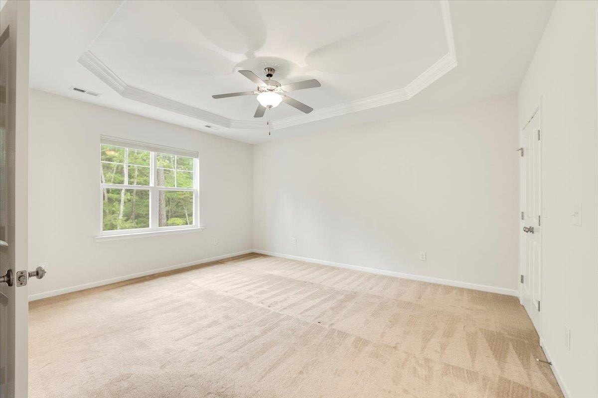 203 Zante Currant Road Durham, NC 27703 - Photo 11 of 28 Trayed ceilings and double windows facing the back wooded area. Nice for sunshine and privacy. Primary Bedroom