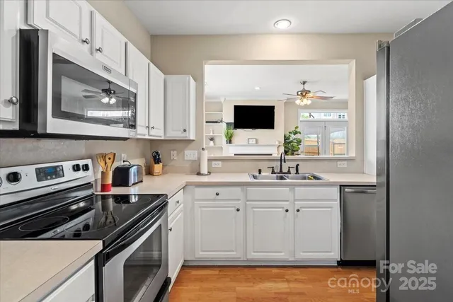 a kitchen with stainless steel appliances a stove a sink and a microwave