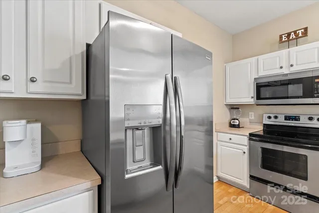 a kitchen with stainless steel appliances and white cabinets