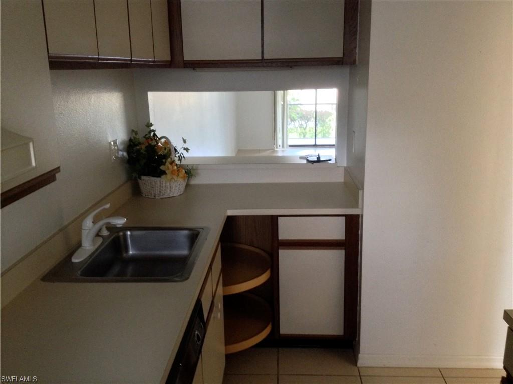 5339 Treetops Drive, Unit T105 Naples, FL 34113 - Photo 15 of 16 a kitchen with a sink and cabinets