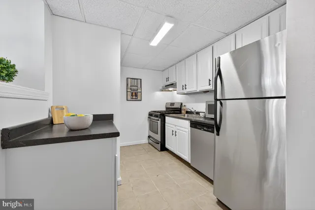 a kitchen with a refrigerator sink stove and cabinets