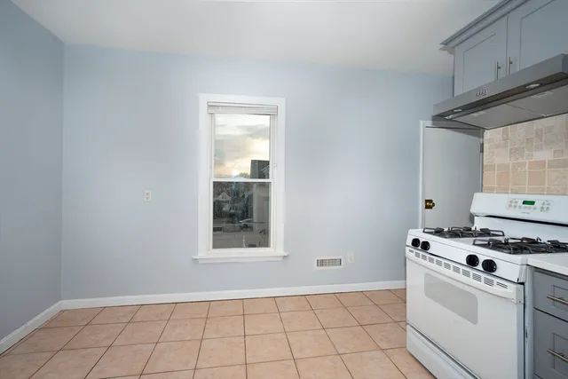 a kitchen with white cabinets a stove top oven and sink