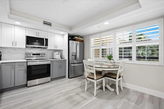 a living room with furniture and a large window with kitchen view