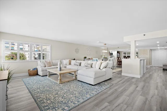 a living room with furniture a fireplace and a dining table with wooden floor