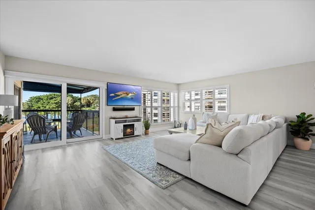 a living room with furniture and a view of kitchen