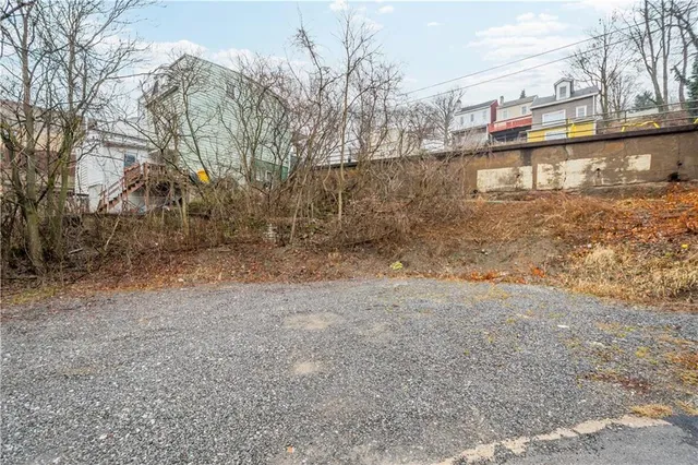 a view of a dry yard with wooden fence