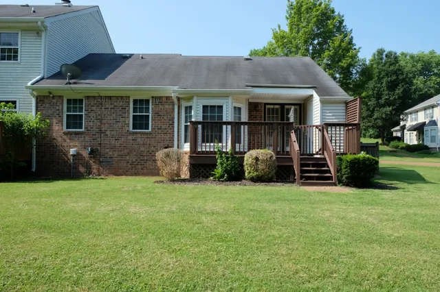 a front view of a house with a yard and trees