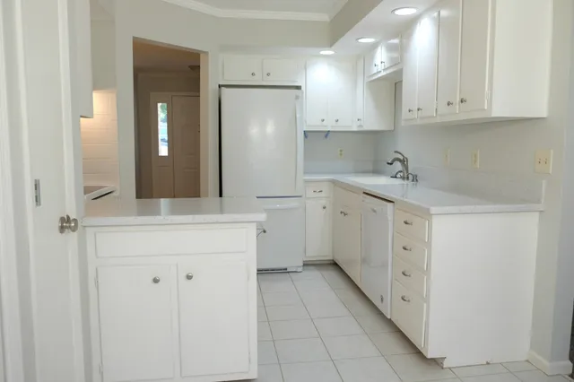 a kitchen with white cabinets appliances and sink