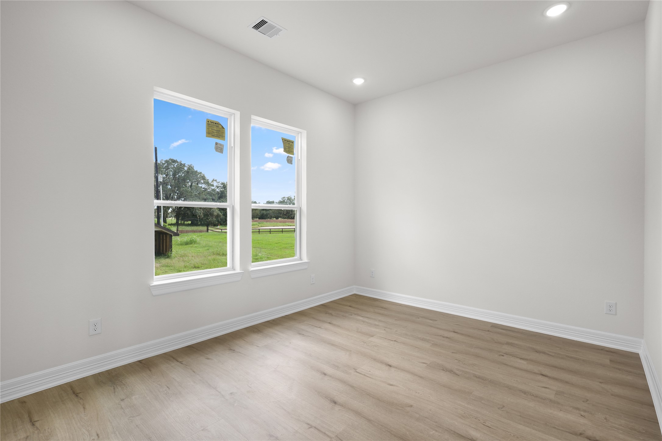 1720 Flintlock Court Angleton, TX 77515 - Photo 13 of 32 an empty room with wooden floor and windows