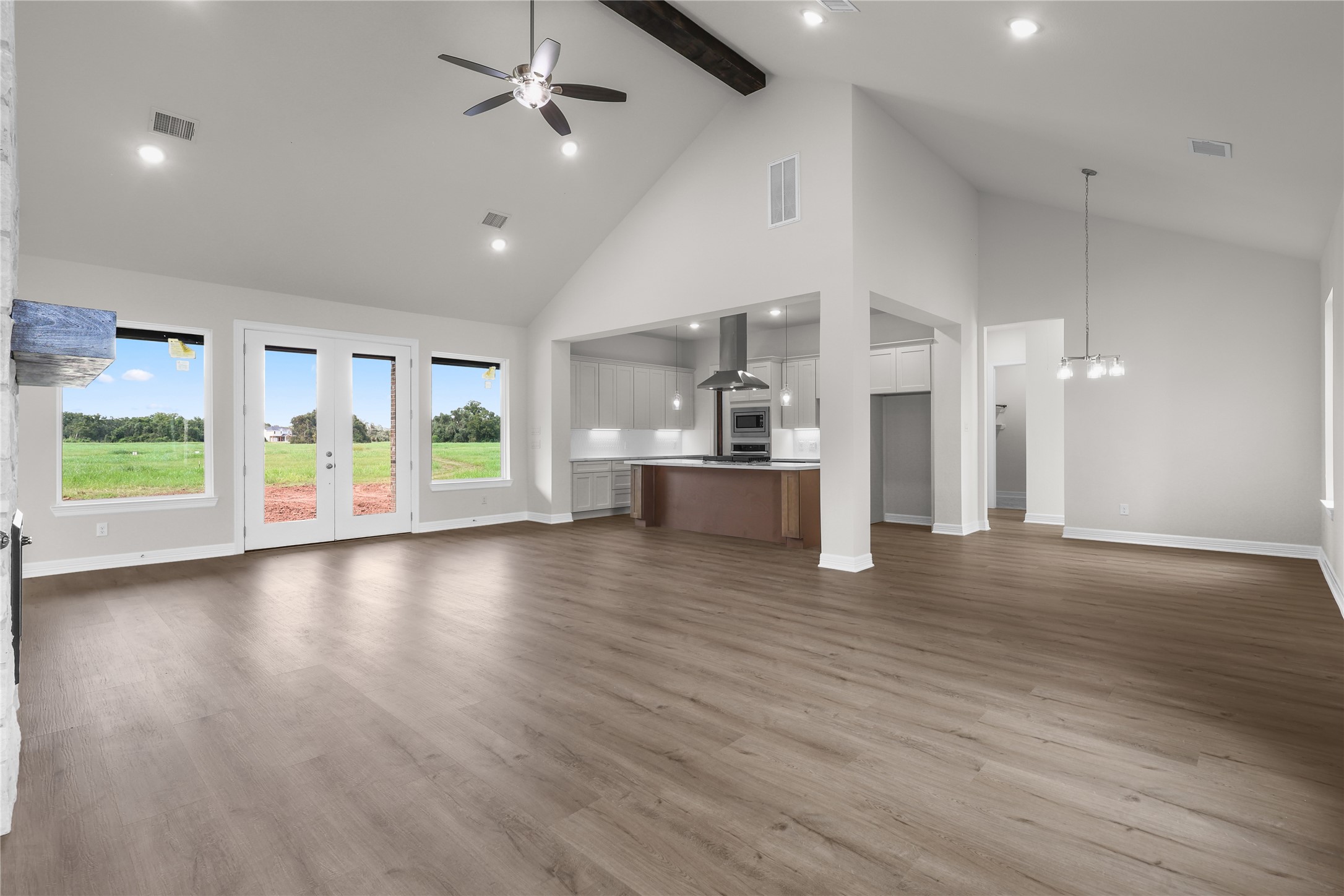 1720 Flintlock Court Angleton, TX 77515 - Photo 6 of 32 an empty room with wooden floor kitchen view and windows