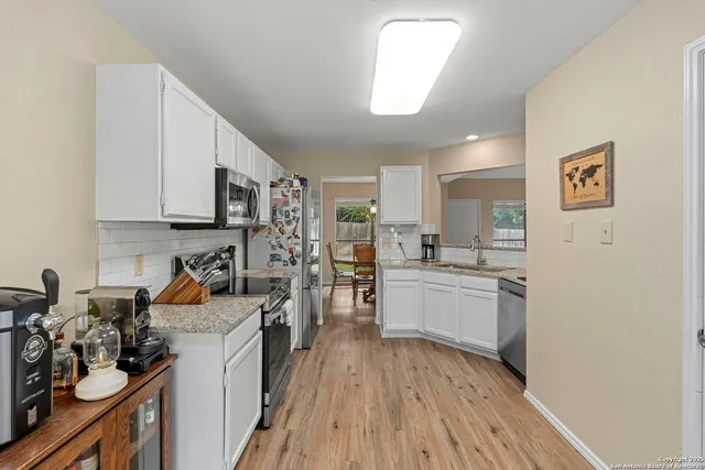 a kitchen with a refrigerator and white cabinets