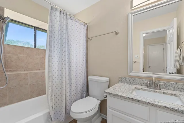 a bathroom with a granite countertop toilet a sink and a mirror