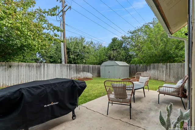 a view of backyard with outdoor seating and green space