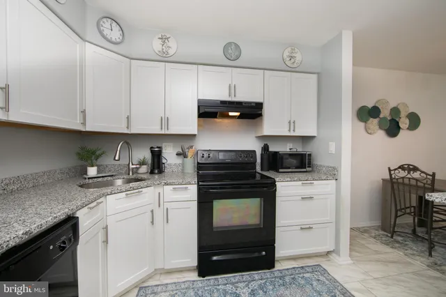 a kitchen with granite countertop a sink and cabinets