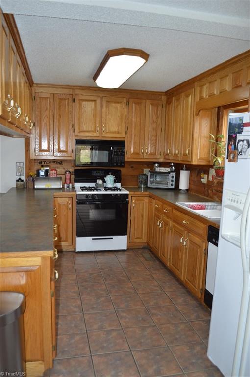 551 Jackson Rd Extension Mount Airy, NC 27030 - Photo 12 of 49 Kitchen with stove, microwave, d/w and refrigerator remaining.