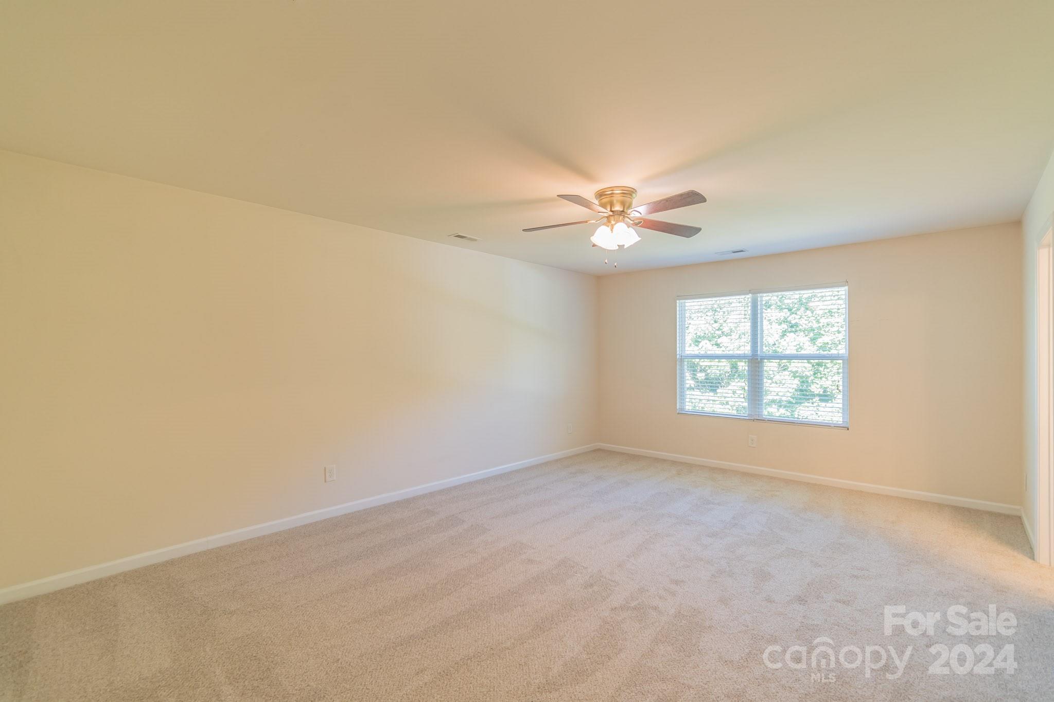 8715 Balsam Bay Road Charlotte, NC 28227 - Photo 12 of 29 an empty room with windows and chandelier fan