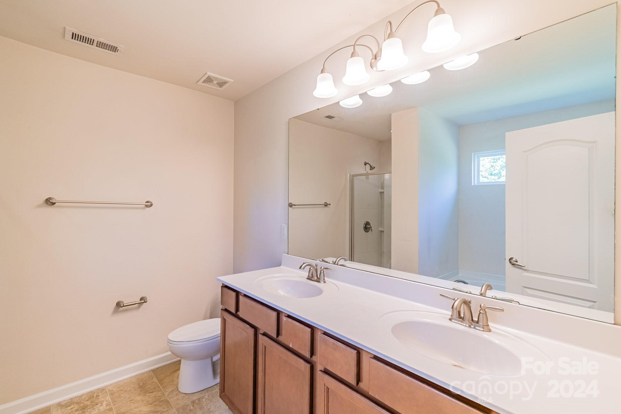 8715 Balsam Bay Road Charlotte, NC 28227 - Photo 14 of 29 a bathroom with a granite countertop sink a toilet and a mirror