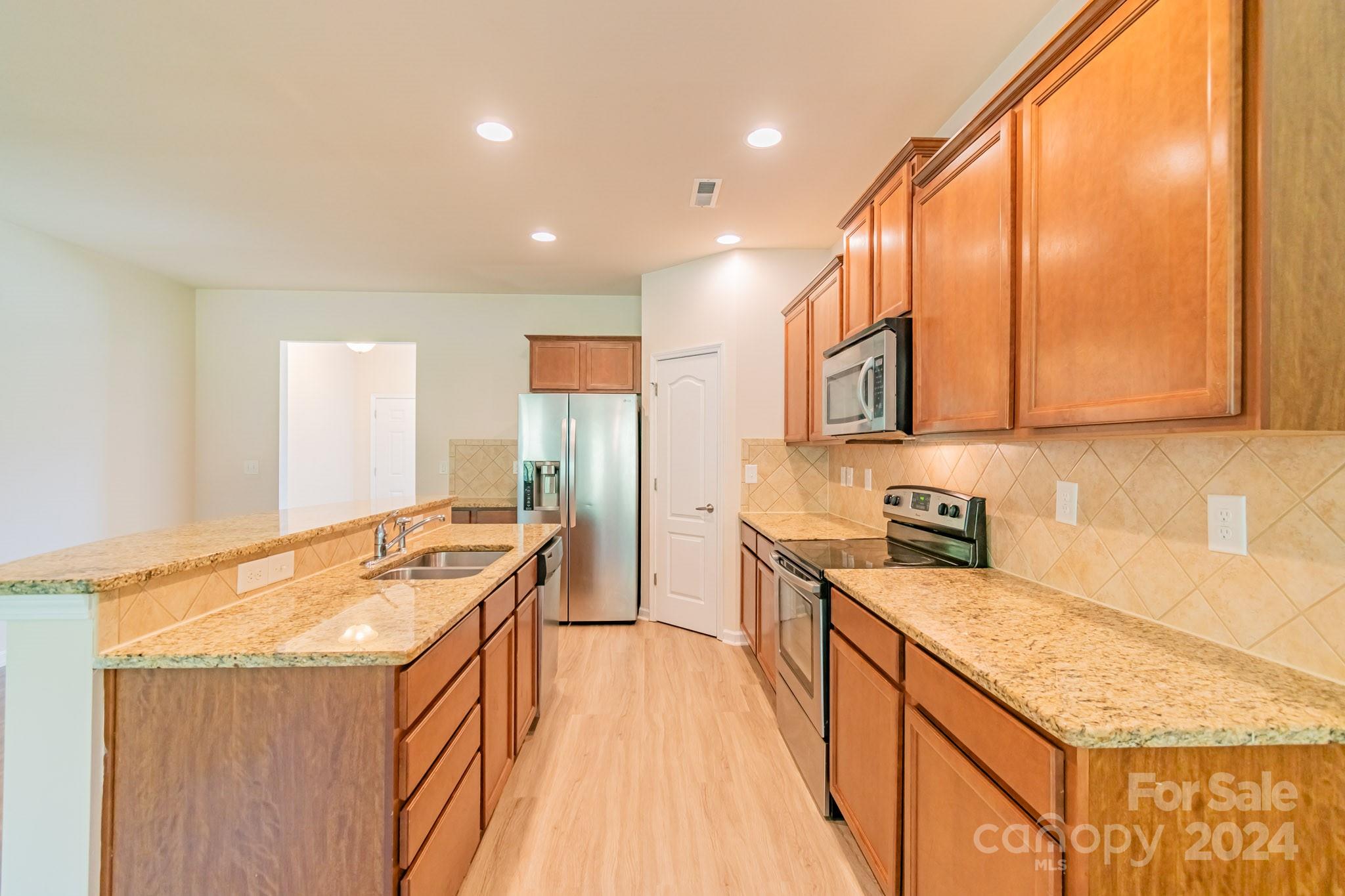 8715 Balsam Bay Road Charlotte, NC 28227 - Photo 6 of 29 a kitchen with stainless steel appliances granite countertop a stove a sink and a refrigerator