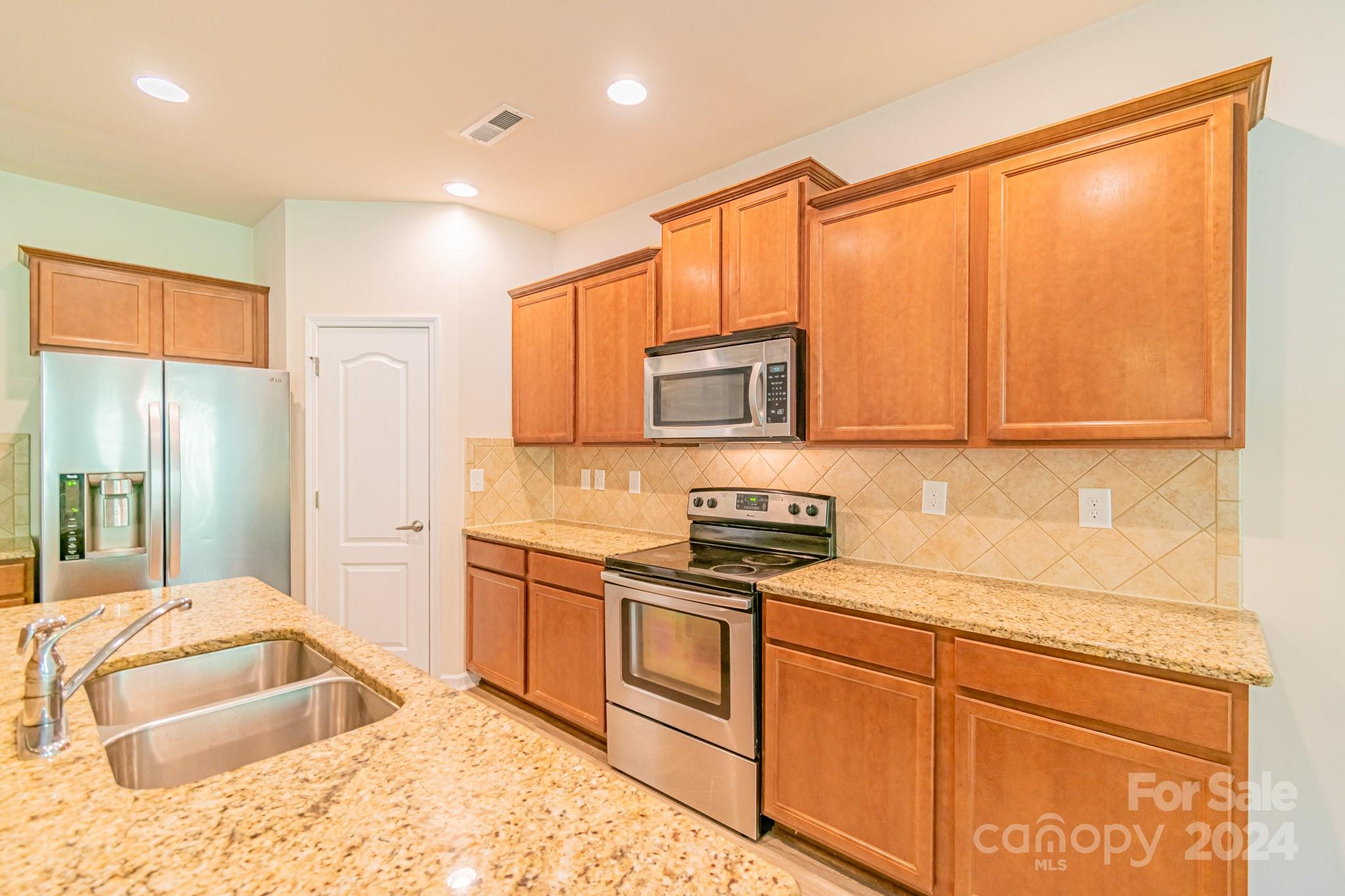 8715 Balsam Bay Road Charlotte, NC 28227 - Photo 7 of 29 a kitchen with stainless steel appliances granite countertop a sink stove and refrigerator