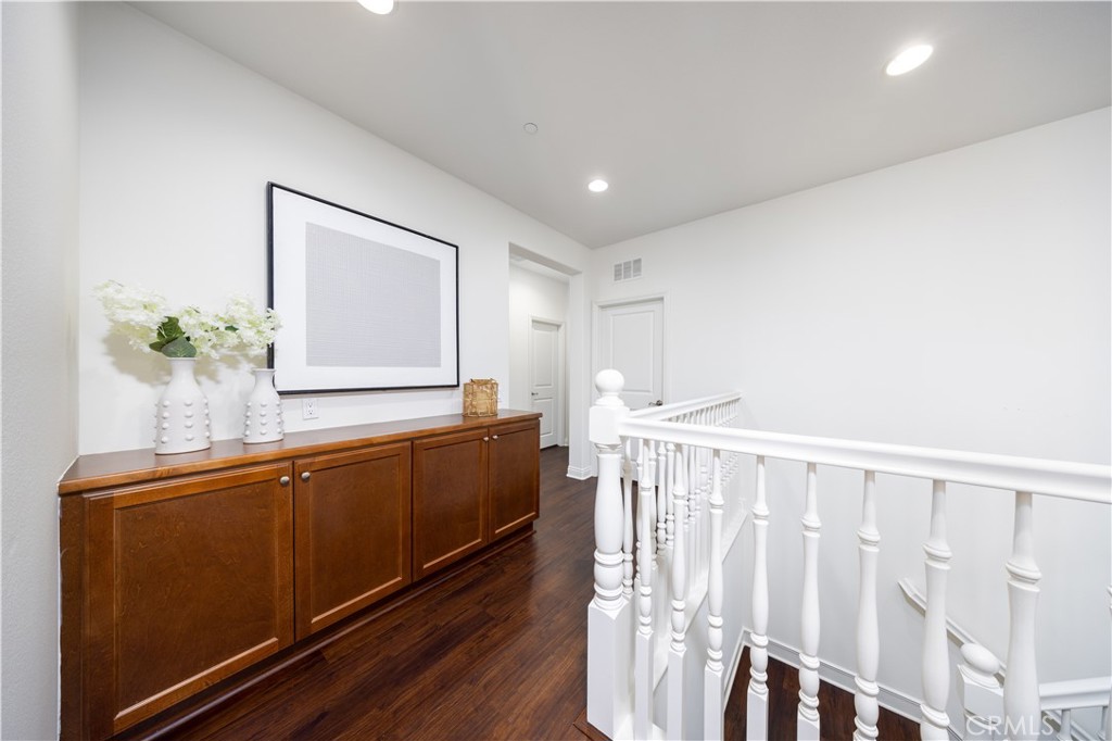130 Yellow Daisy Irvine, CA 92618 - Photo 25 of 48 a hallway with a large mirror and wooden floor