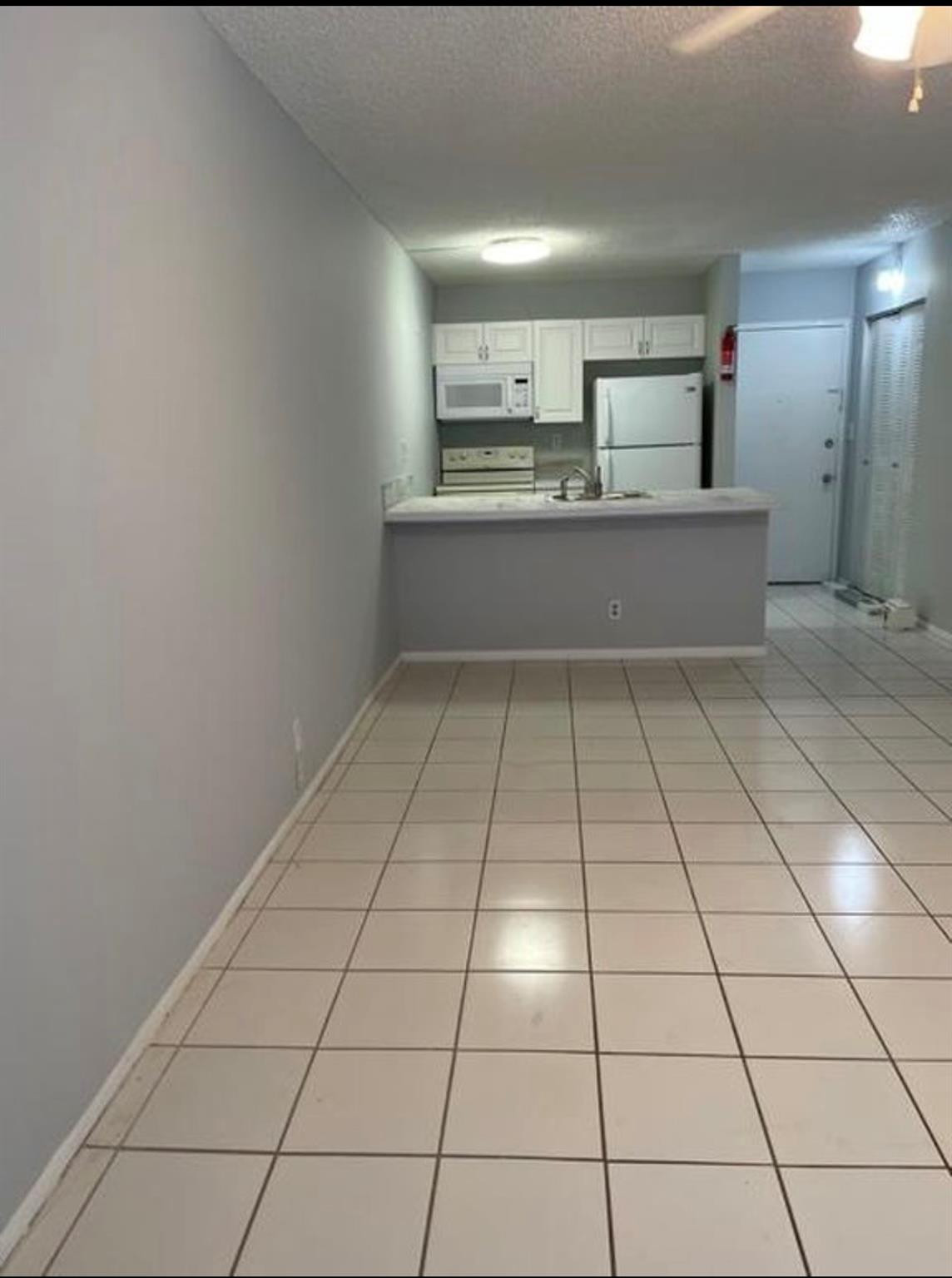 2701 Riverside Drive, Unit 107B Coral Springs, FL 33065 - Photo 2 of 13 a view of a refrigerator in kitchen and wooden floor