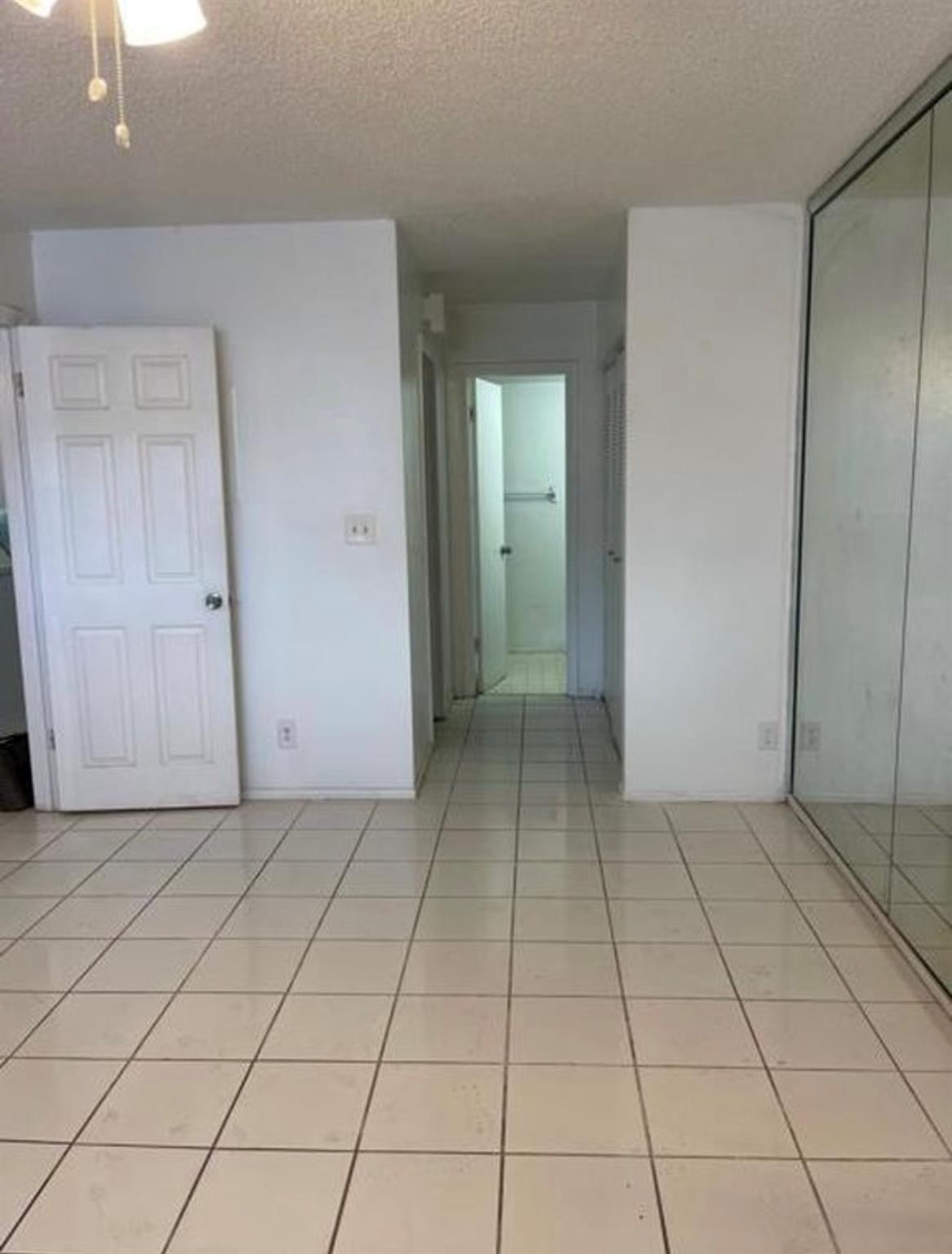 2701 Riverside Drive, Unit 107B Coral Springs, FL 33065 - Photo 5 of 13 an empty room with cabinet and mirror