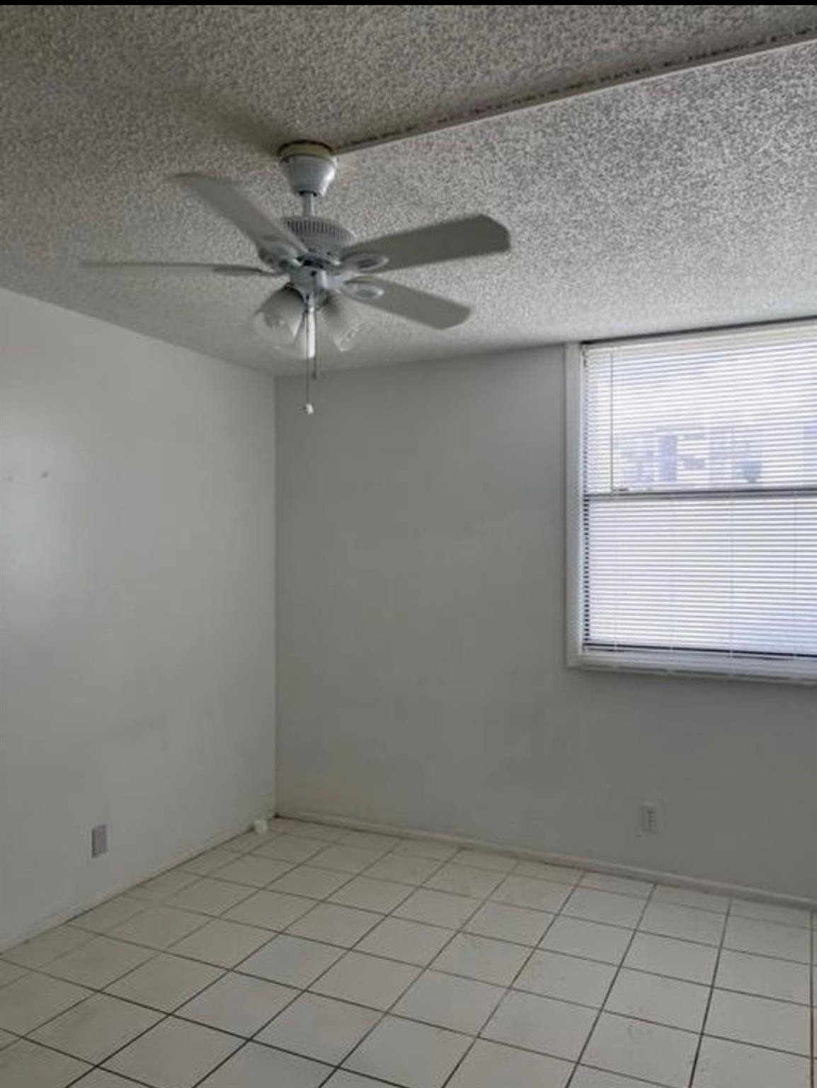 2701 Riverside Drive, Unit 107B Coral Springs, FL 33065 - Photo 6 of 13 an empty room with windows and fan