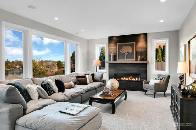 a living room with furniture fireplace and a large window