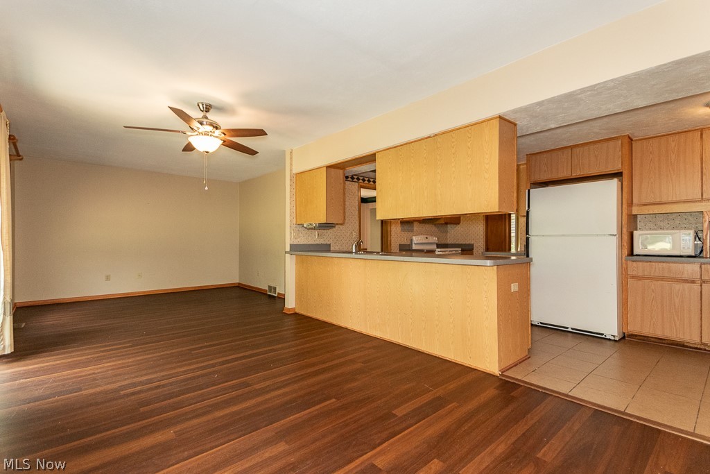4517 Mackall Road Cleveland, OH 44121 - Photo 24 of 41 Kitchen with backsplash, ceiling fan, white appliances, and hardwood / wood-style floors